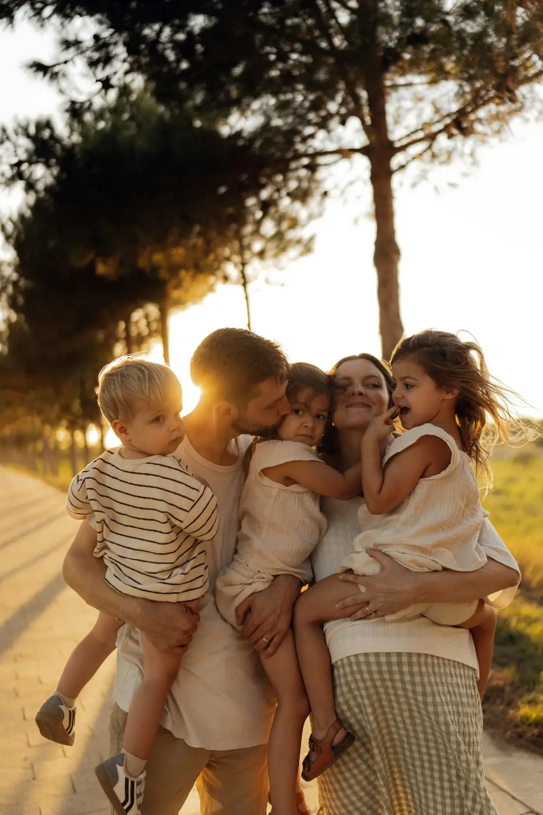 A family holding their children close at sunset